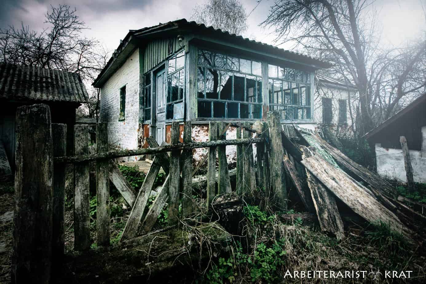 Zaun und verlassenes Wohnhaus in Paryshew – Tschernobyl